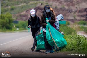 Girls picking up trash at cleaning campaign in Huacarpay