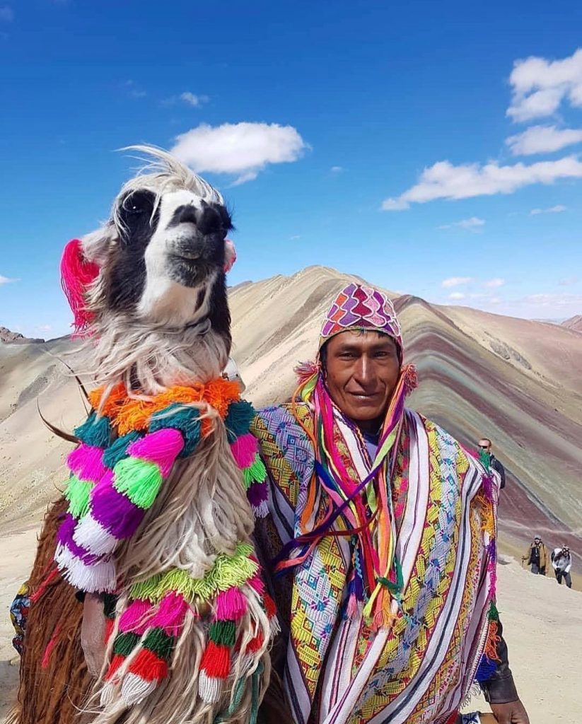 Llama and man dressed in traditional costumes