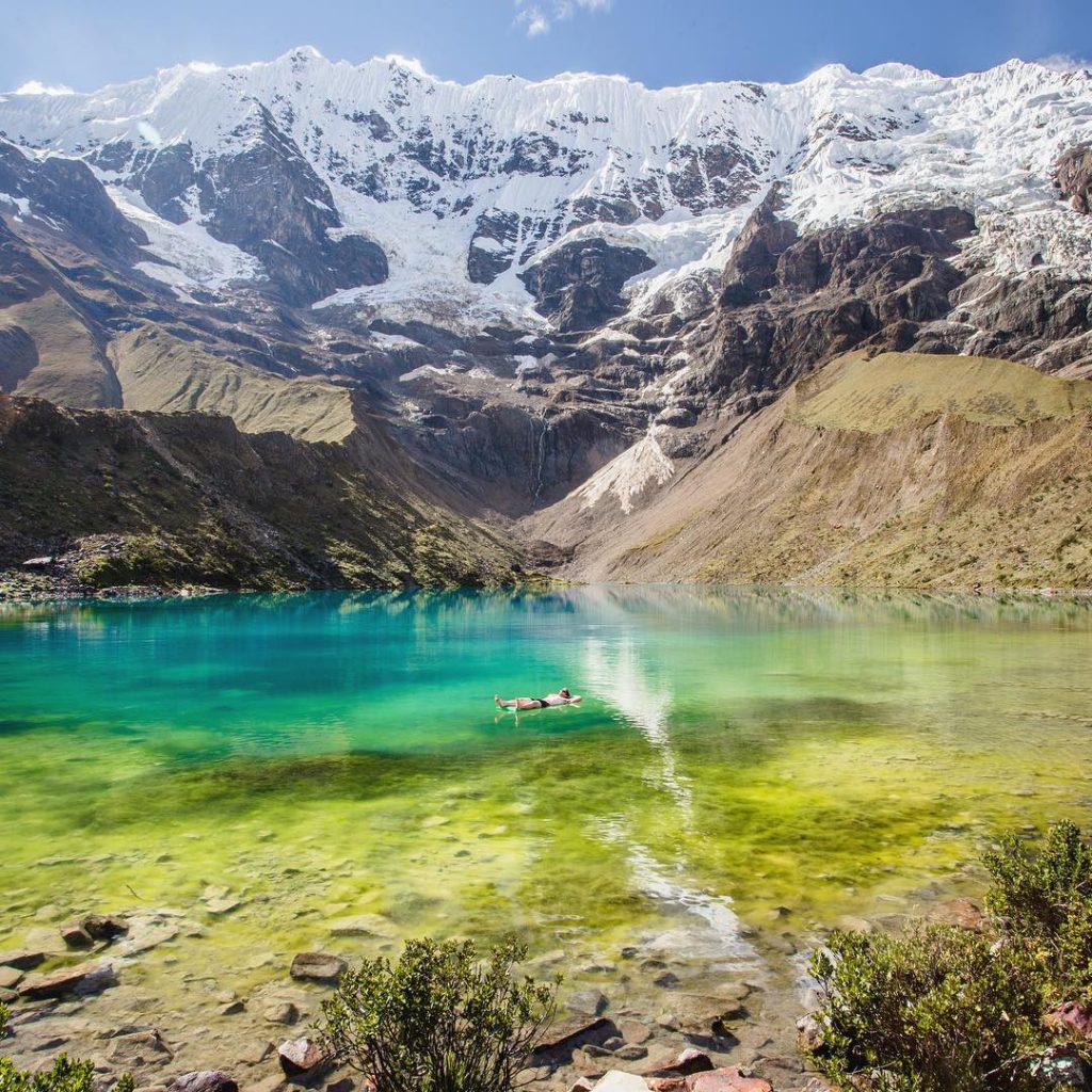Man at a blue lake and mountains