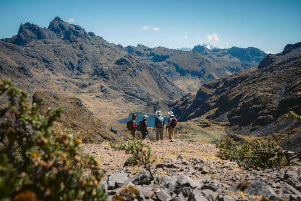 Group of tourists admiring an Andean mountain landscape on the Lares route.