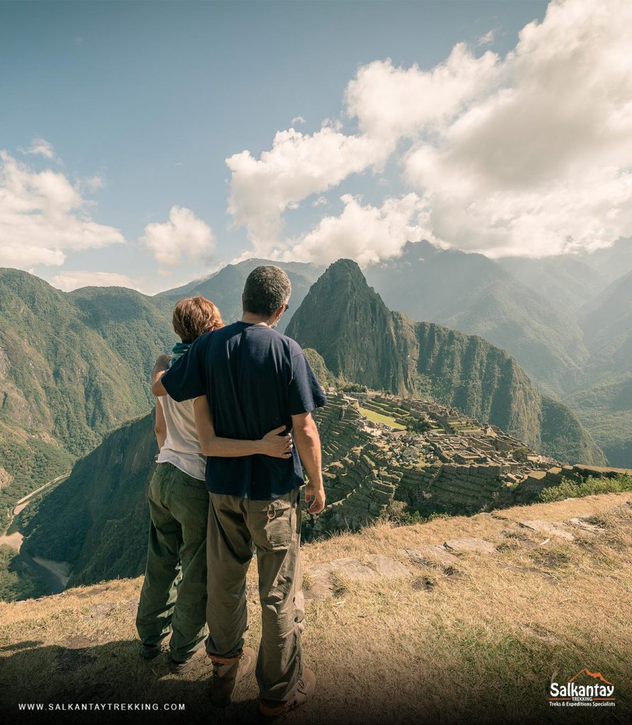 A couple of tourists embracing watching Machu Picchu