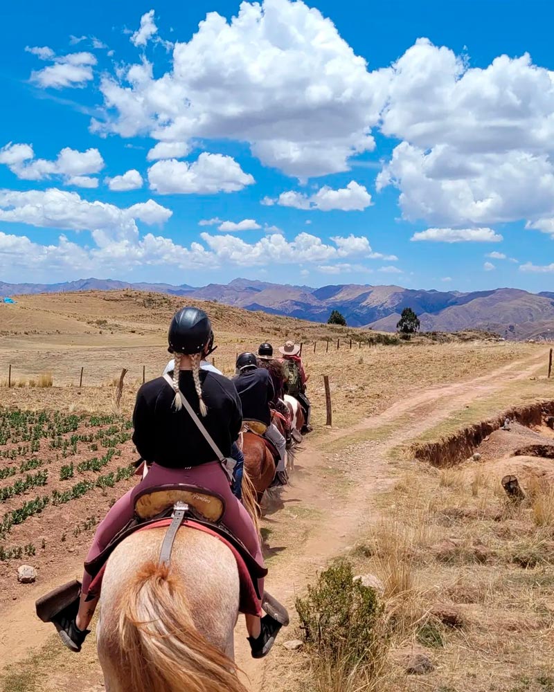 foreigners horse riding in sacsayhuaman