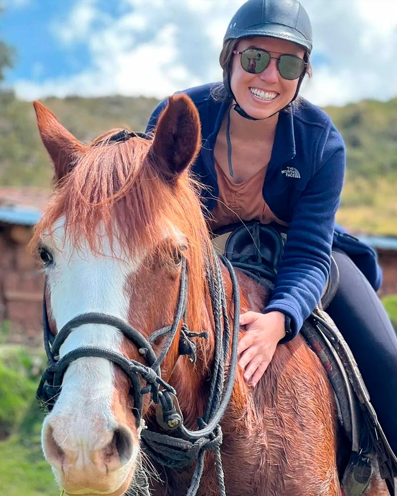 happy woman horse riding in cusco