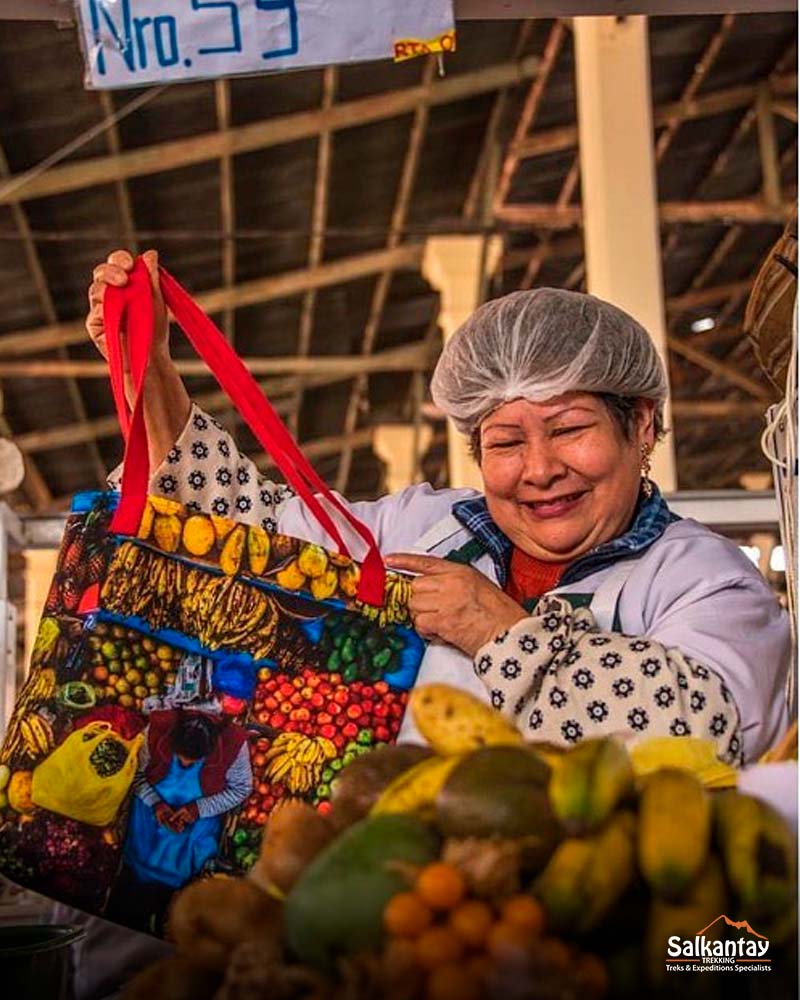 woman at the san pedro market holding a colorful fruit bag