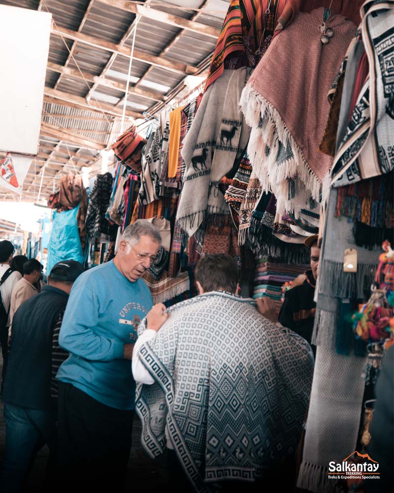 foreigners buying souvenirs at the san pedro market in cusco peru