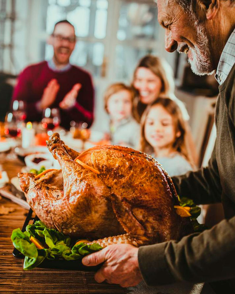 Man holding the roast turkey at the thansgiving day