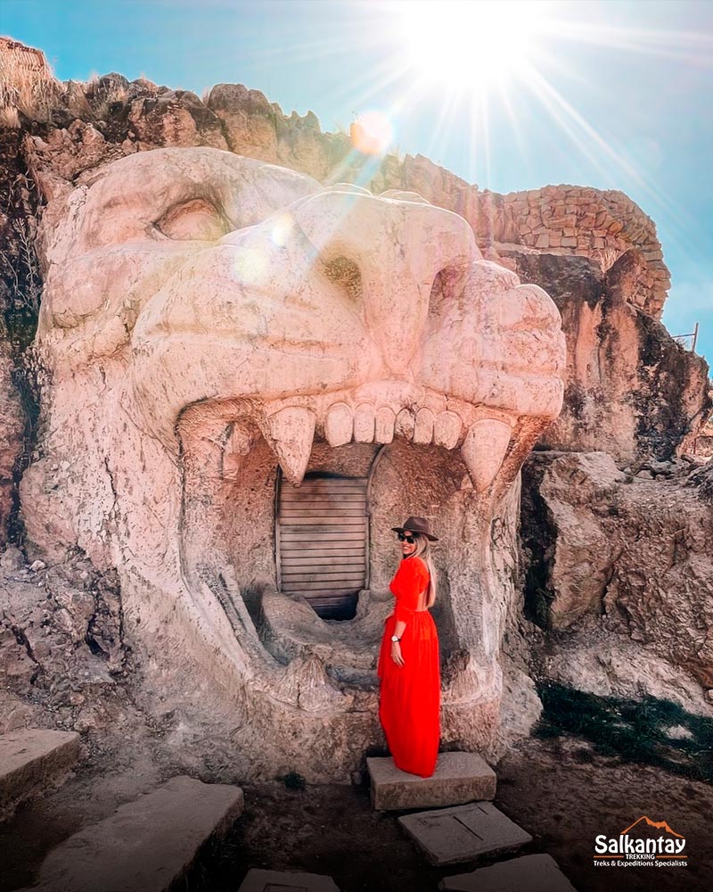 woman in a maxi red dress at the dwelling of the gods in cusco