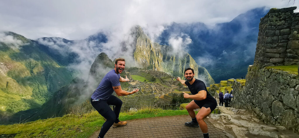 Two male tourists pointing out the Inca city of Machu Picchu.