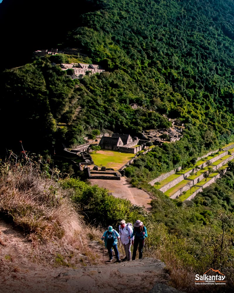 Three tourists against the backdrop of the Choquequirao citadel