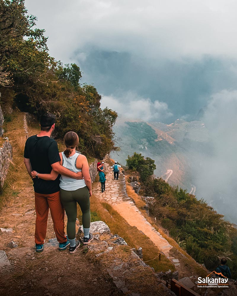 A tourist couple viewing the citadel of Machu Picchu from the Sun Gate or Inti Punku