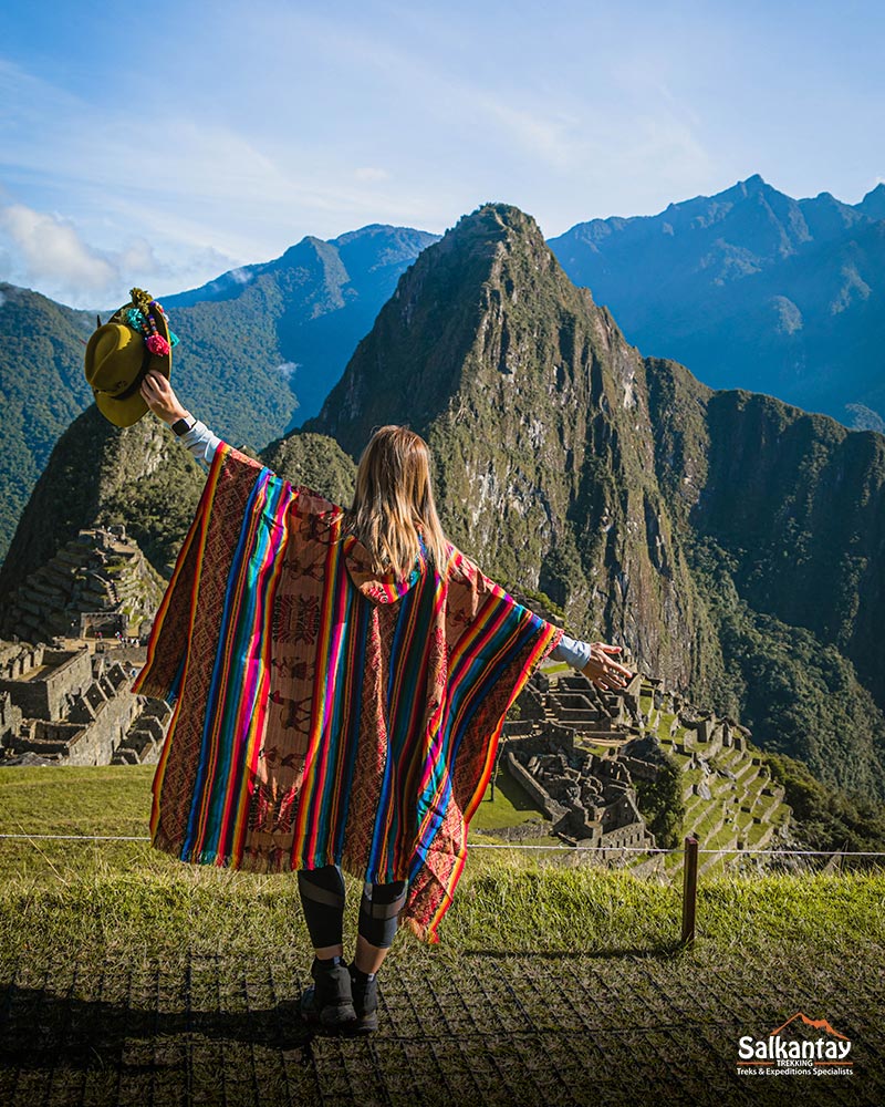 Tourist women with Andean poncho in Machu Picchu on a sunny day