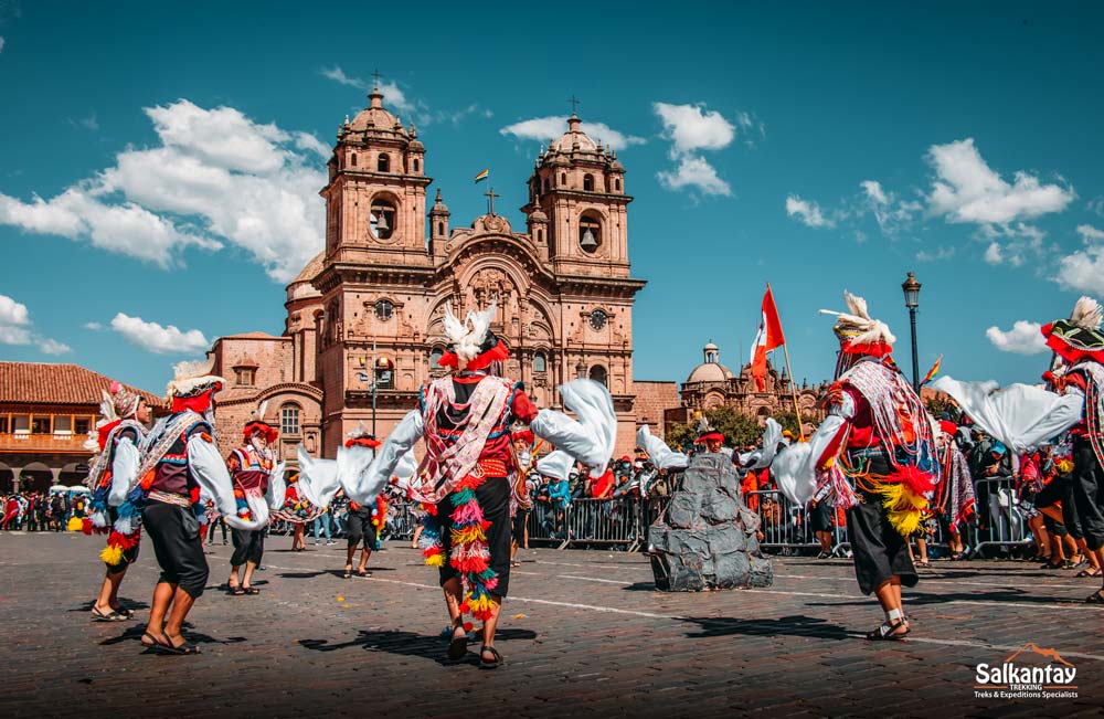 People dressed in red typical costume dancing in the main square. Traditions in Cusco