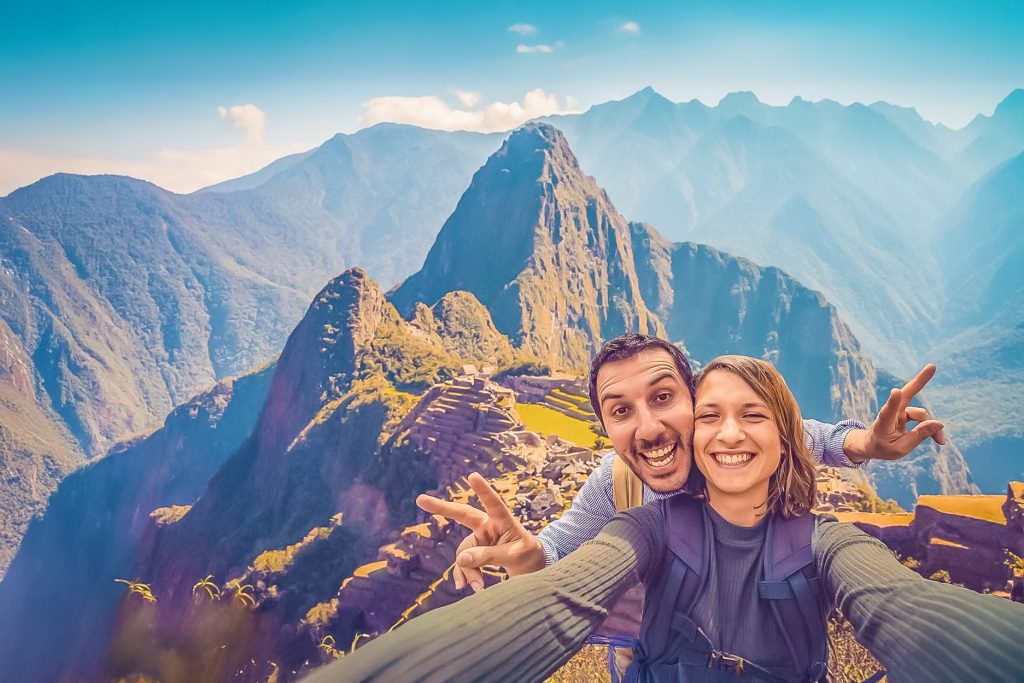 A happy couple of tourists in the citadel of Machu Picchu