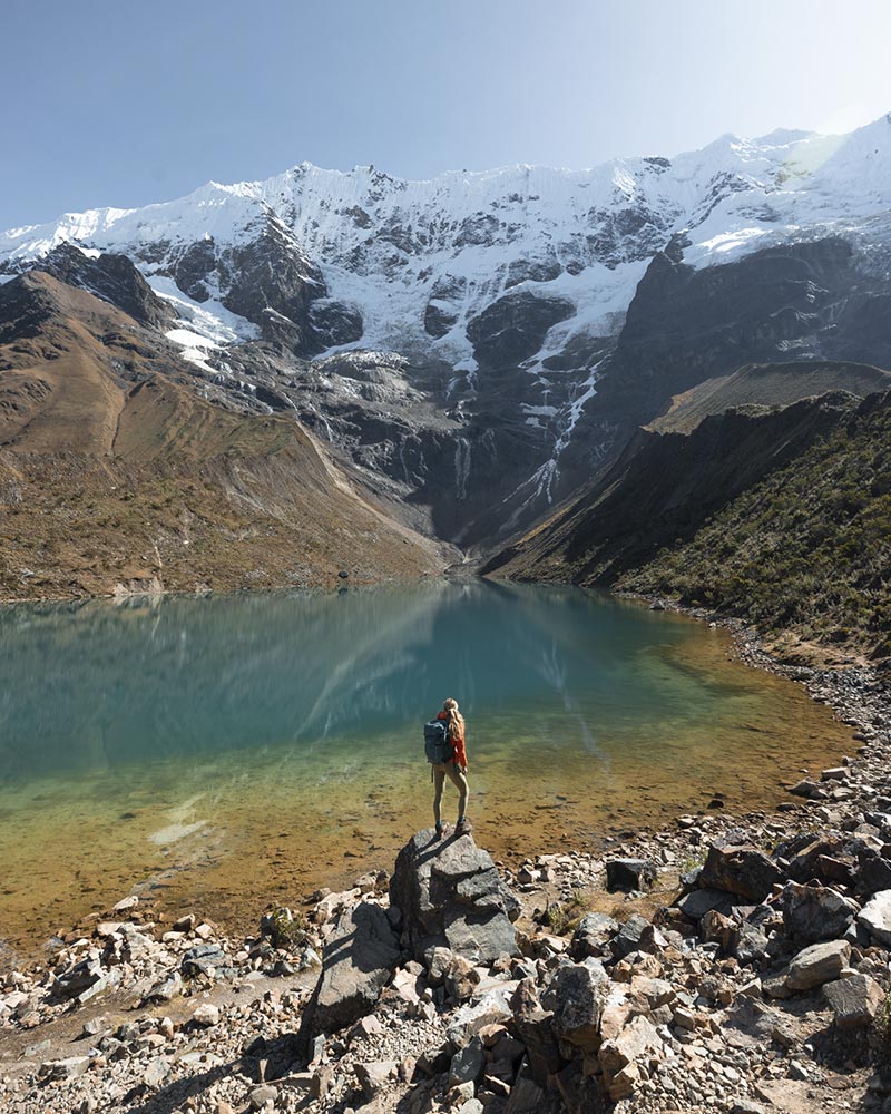 Tourist posing at Humantay Lake on the Salkantay Trail