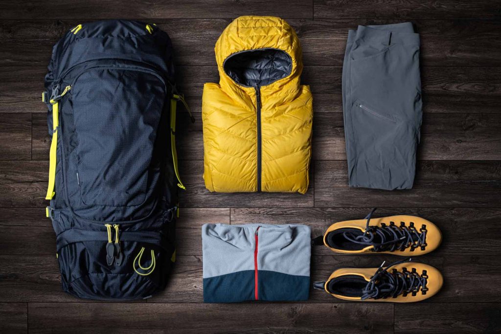 Clothing for hiking or trekking: waterproof jacket, boots, sweater, and backpack