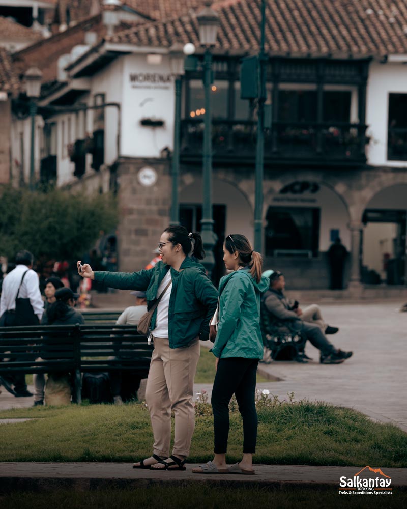 Two tourists taking a selfie in the main square of the city of Cusco.