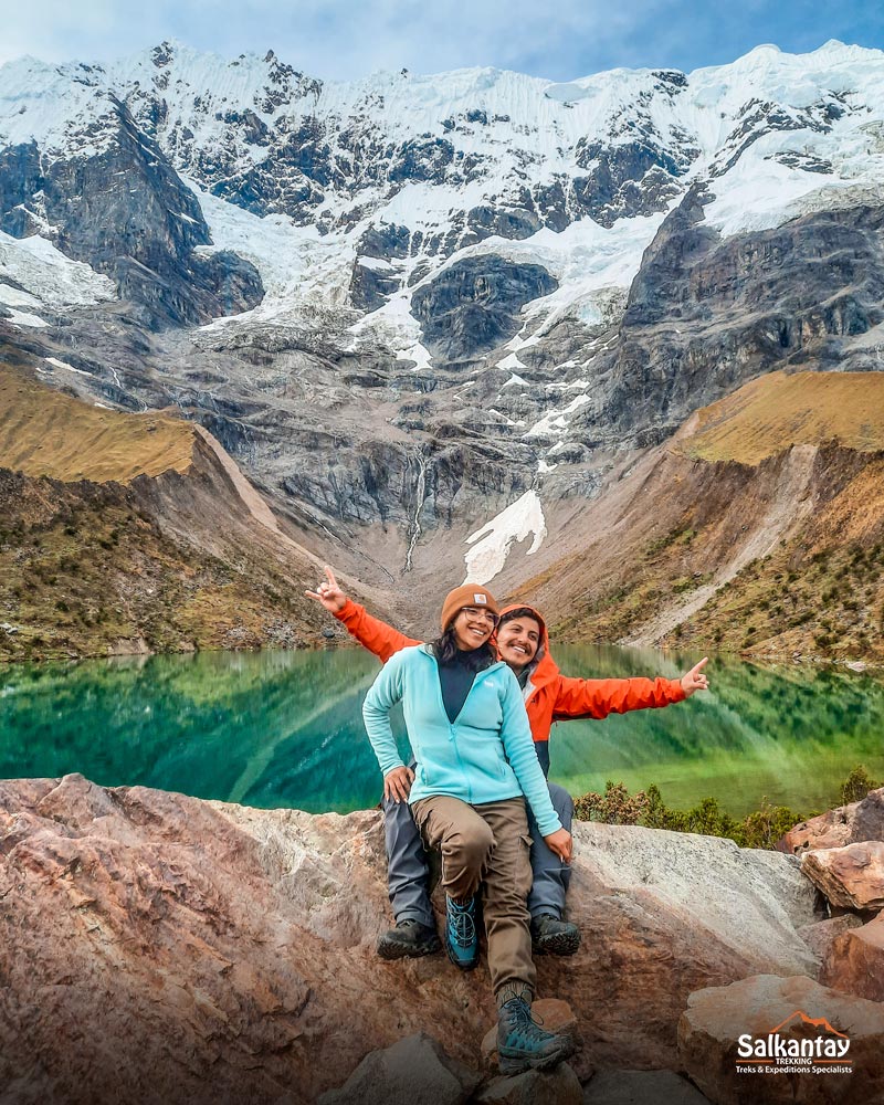 Two tourists in the marvelous Humantay lake on the Salkantay route.