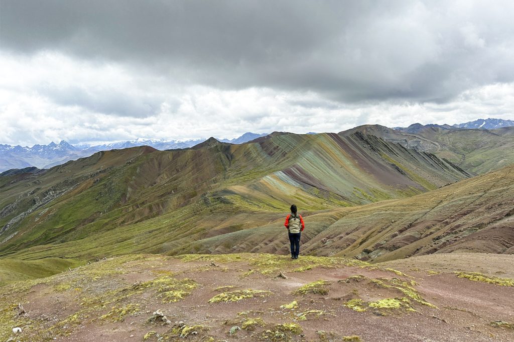 Tourist on his back looking at the Colored Mountain of Palccoyo