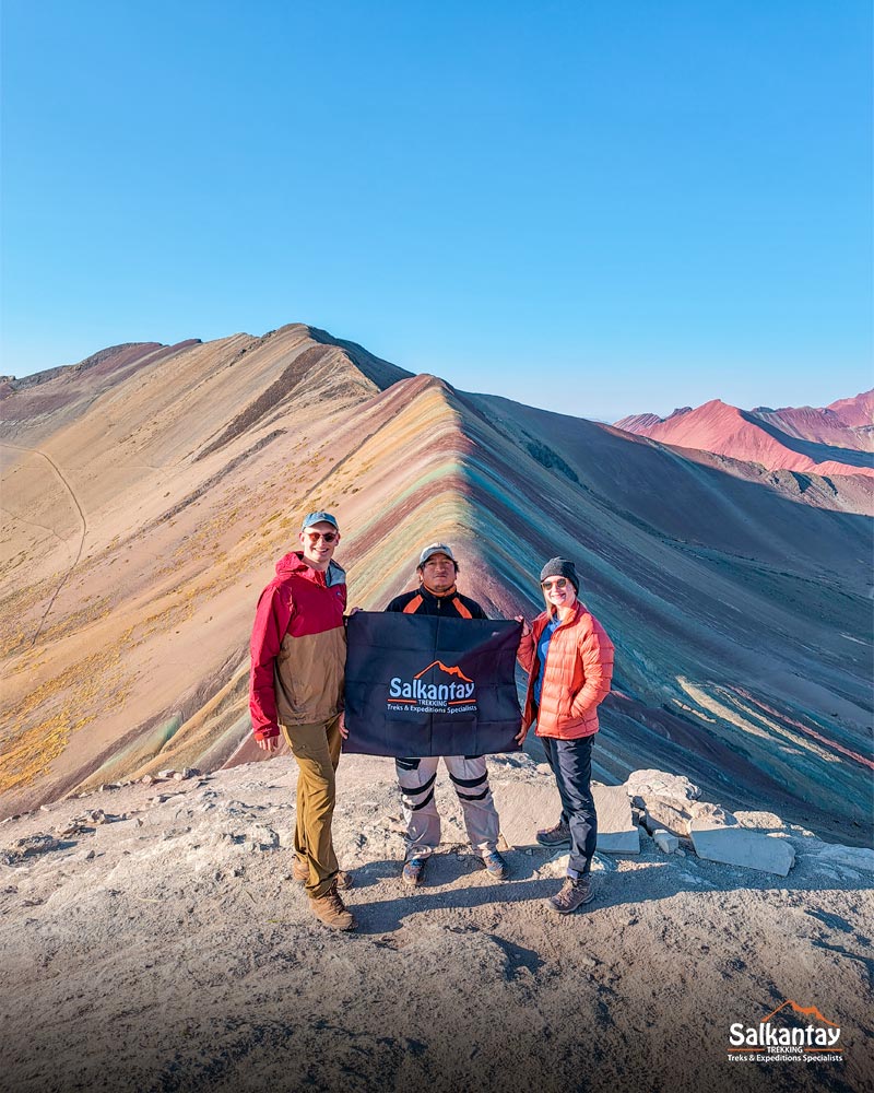 Two tourists and your guide on the colorful mountain of Vinicunca