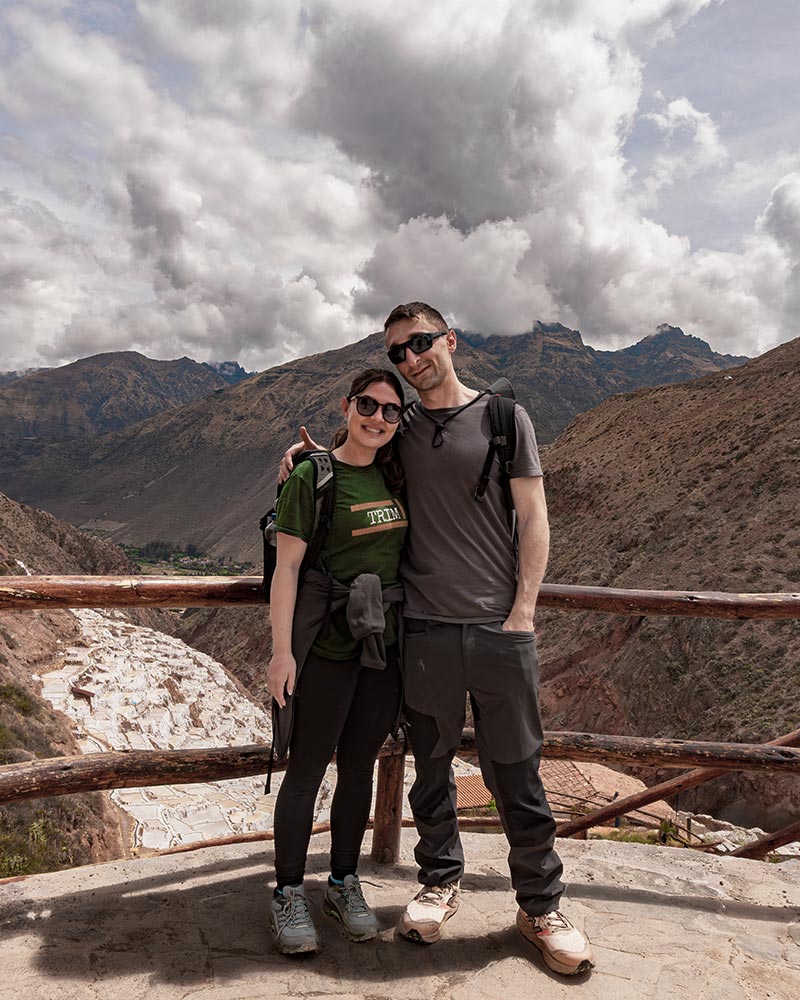 A couple at the viewpoint overlooking the Maras salt flats in the Sacred Valley