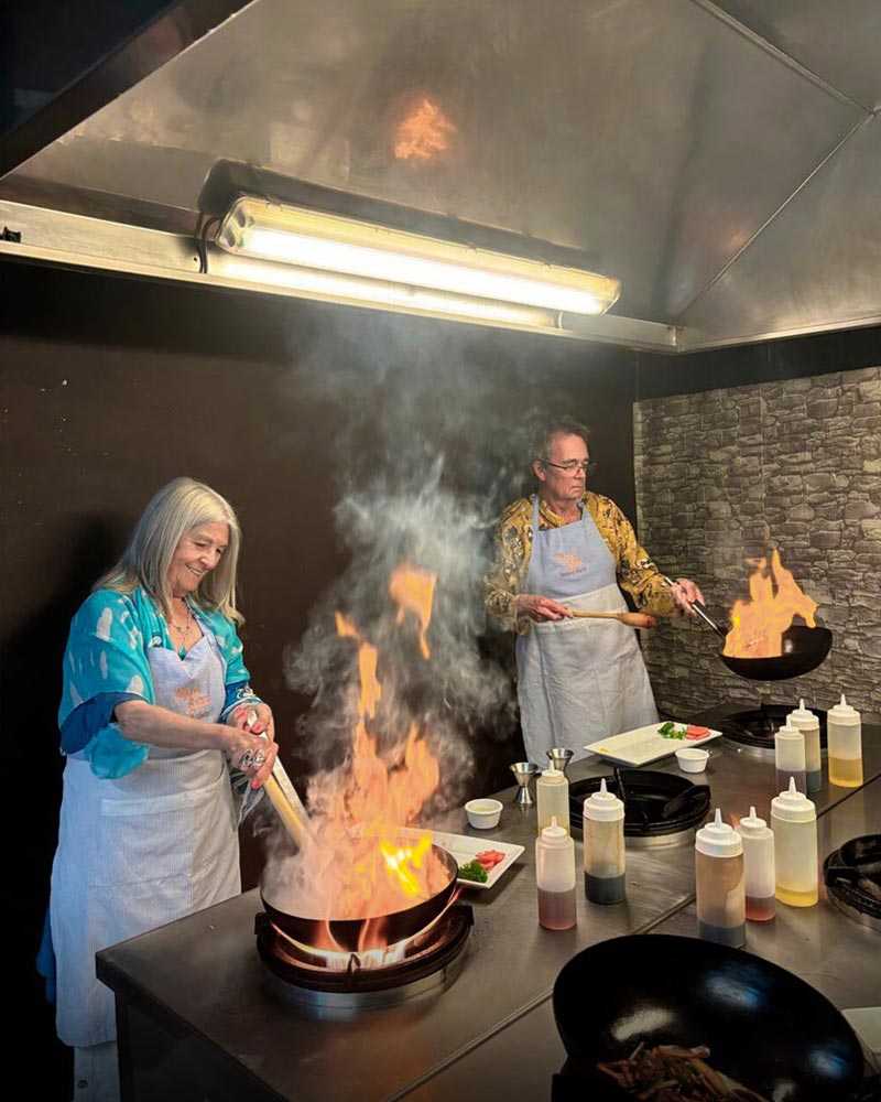 A couple preparing lomo saltado at Marcelo Batata's restaurant