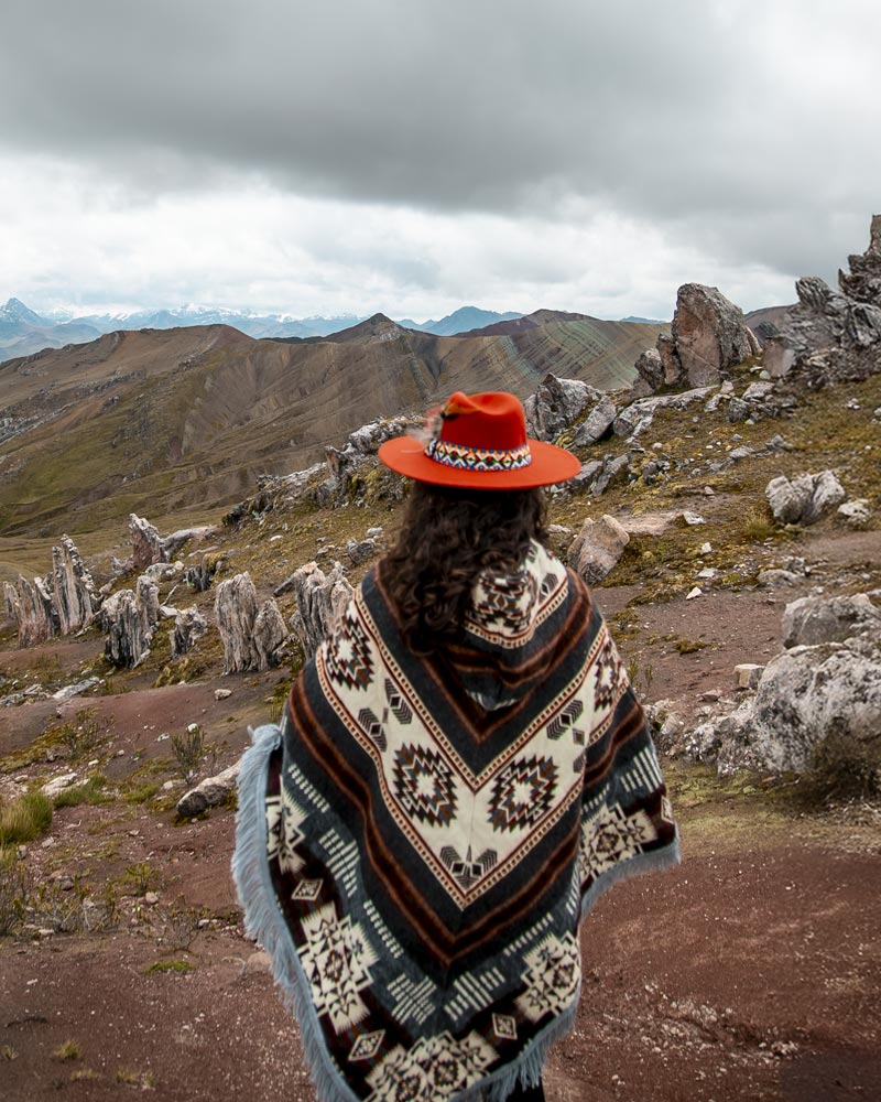 Tourist in Andean clothing on the colorful mountain of Palccoyo