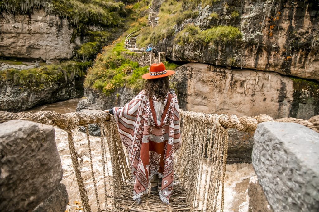 Tourist with Andean poncho on the Q'eswachaka Bridge