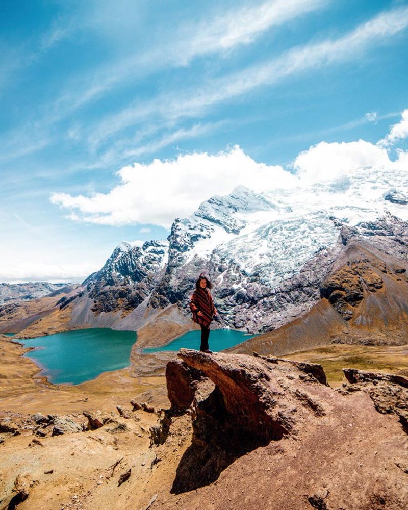 Tourist in Andean poncho with Ausangate Mountain backdrop