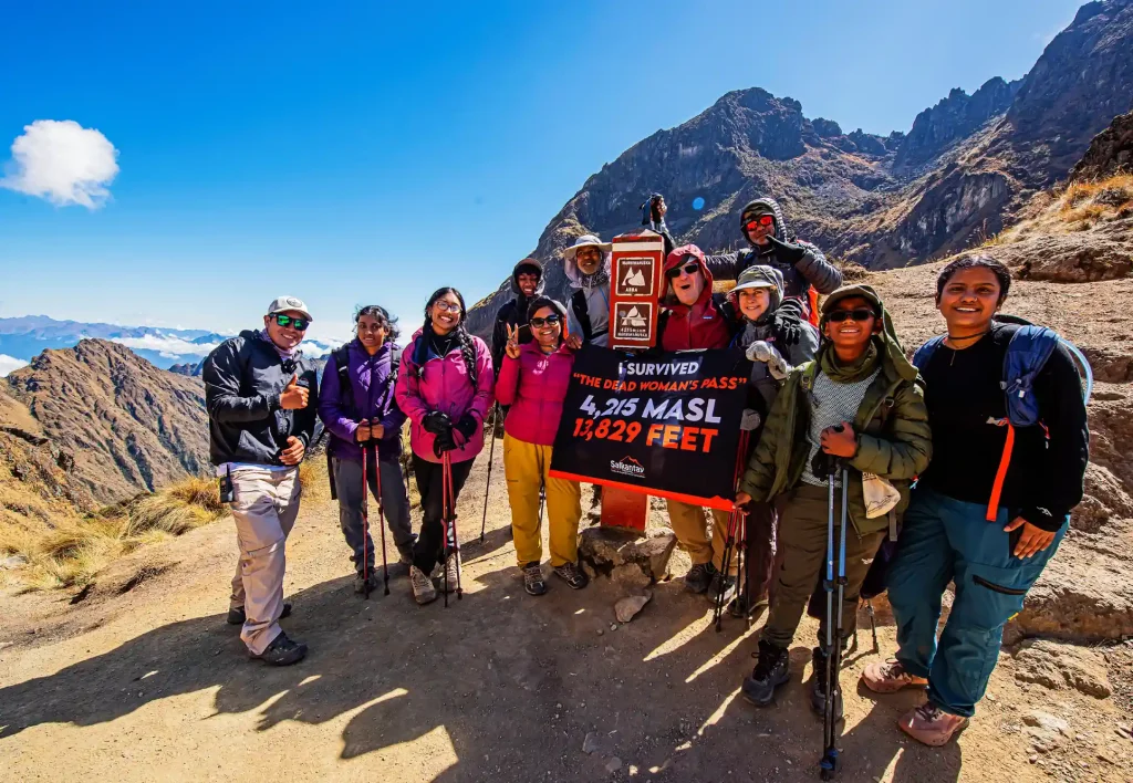 Group of happy tourists on the Inca Trail, Warmiwañusca Pass—dead woman, highest point