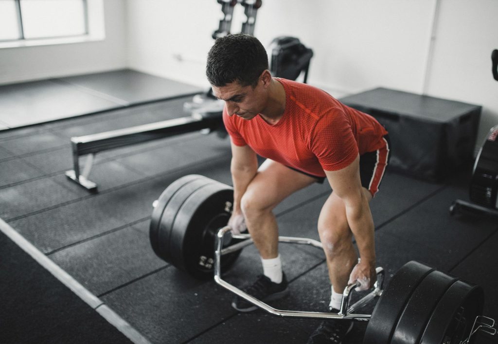 Person training for hiking by doing deadlifts at the gym