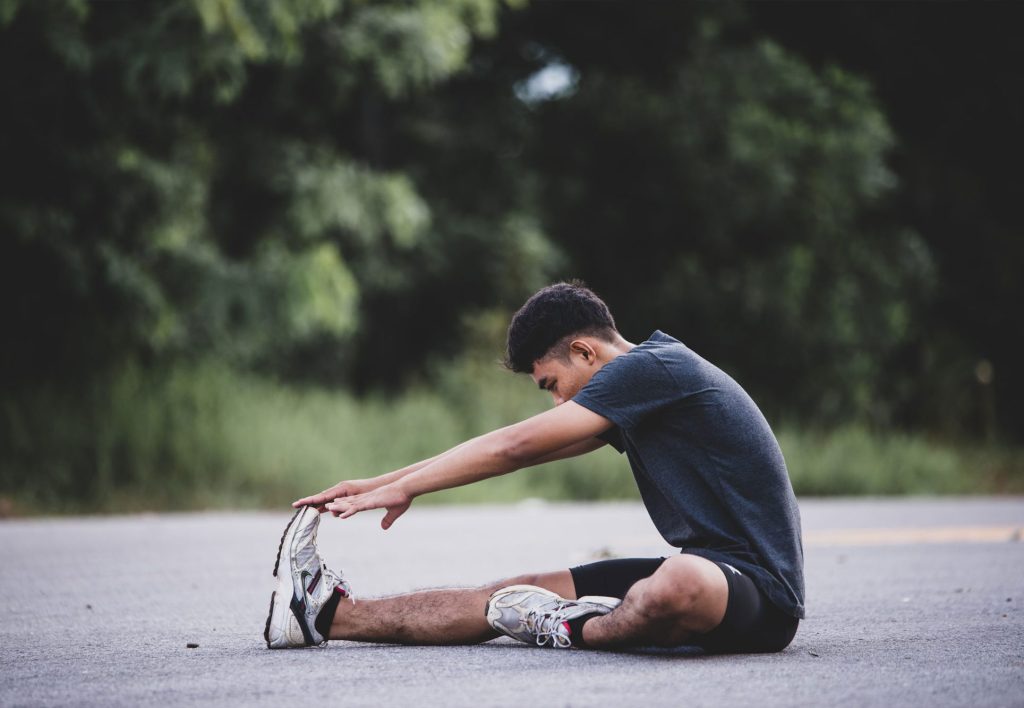 Person doing stretching exercise at the street