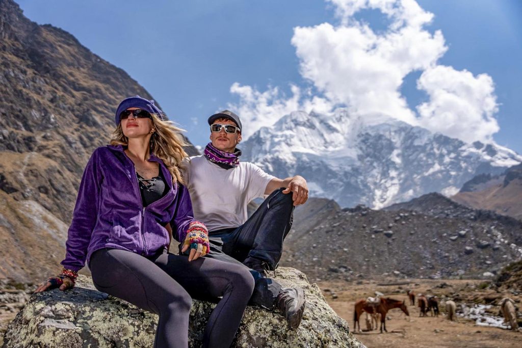 Couple of tourists posing under the snow-capped Salkantay