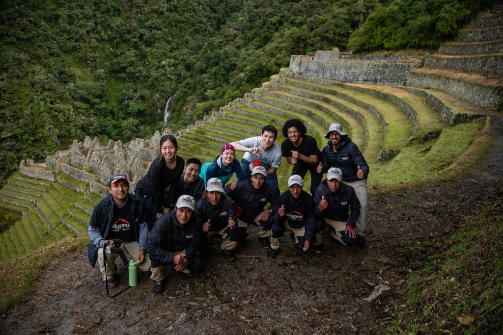 Group of tourists and hiking team at the Wiñay Wayna archaeological site on the Inca Trail.