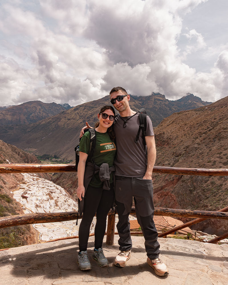 Couple of tourists at the viewpoint of the Maras salt pans