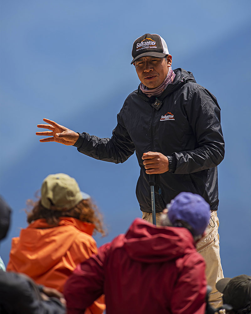 Tour guide on the Salkantay Trek with a group of tourists on the Inca Trail, explaining