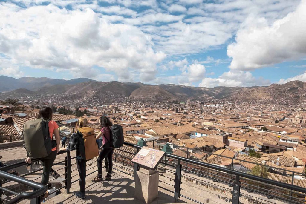 Tourists look for places to stay in Cusco from the San Blas viewpoint, which offers a panoramic view