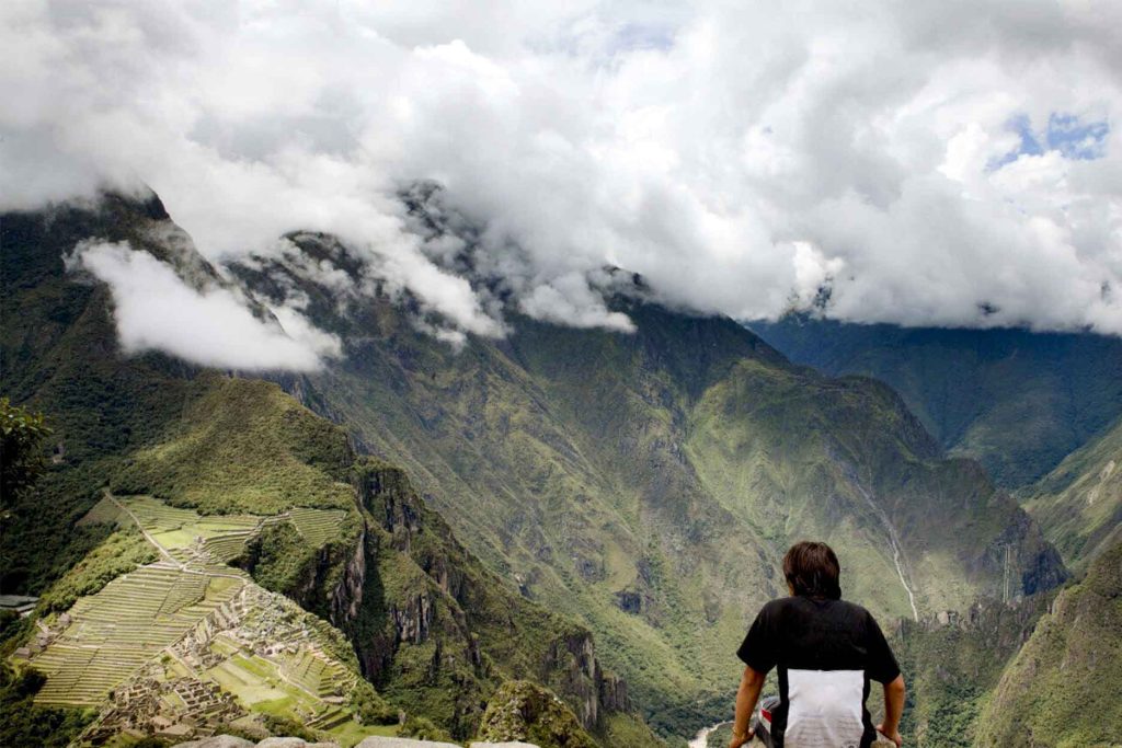A tourist catching their breath while looking out over the Inca citadel of Machu Picchu