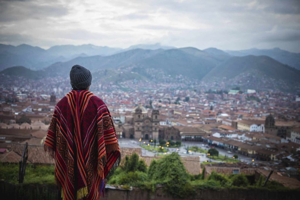 A man looking out over the cityscape of Cusco from the San Cristóbal viewpoint