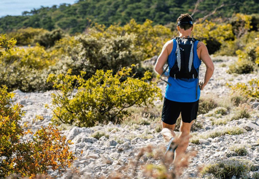 Person wearing a hydration vest while trail running