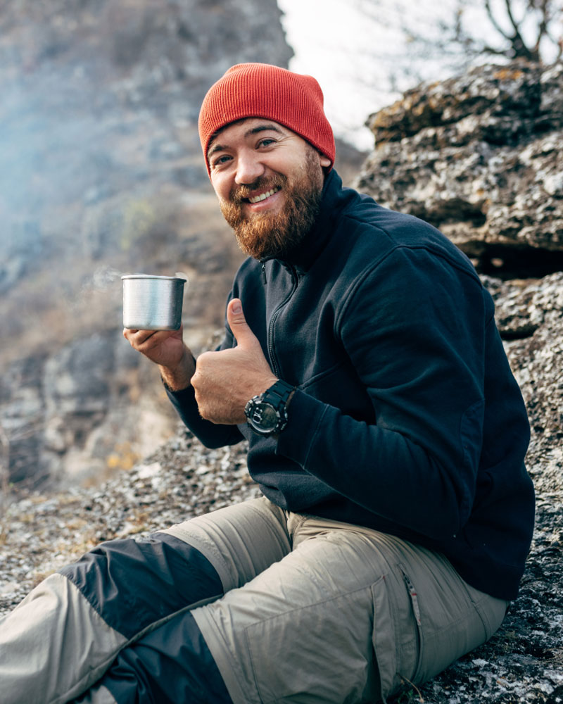 A tourist drinking coca tea on a hike