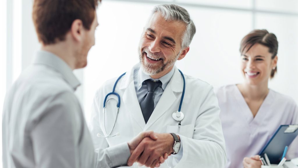 A patient talking to their doctor during a medical consultation in a clinic office.