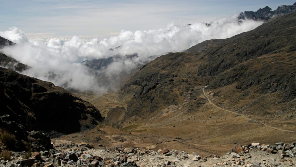 Hikers walking along the ancient pre-Inca stone paving of the Takesi Trail through the Andes.