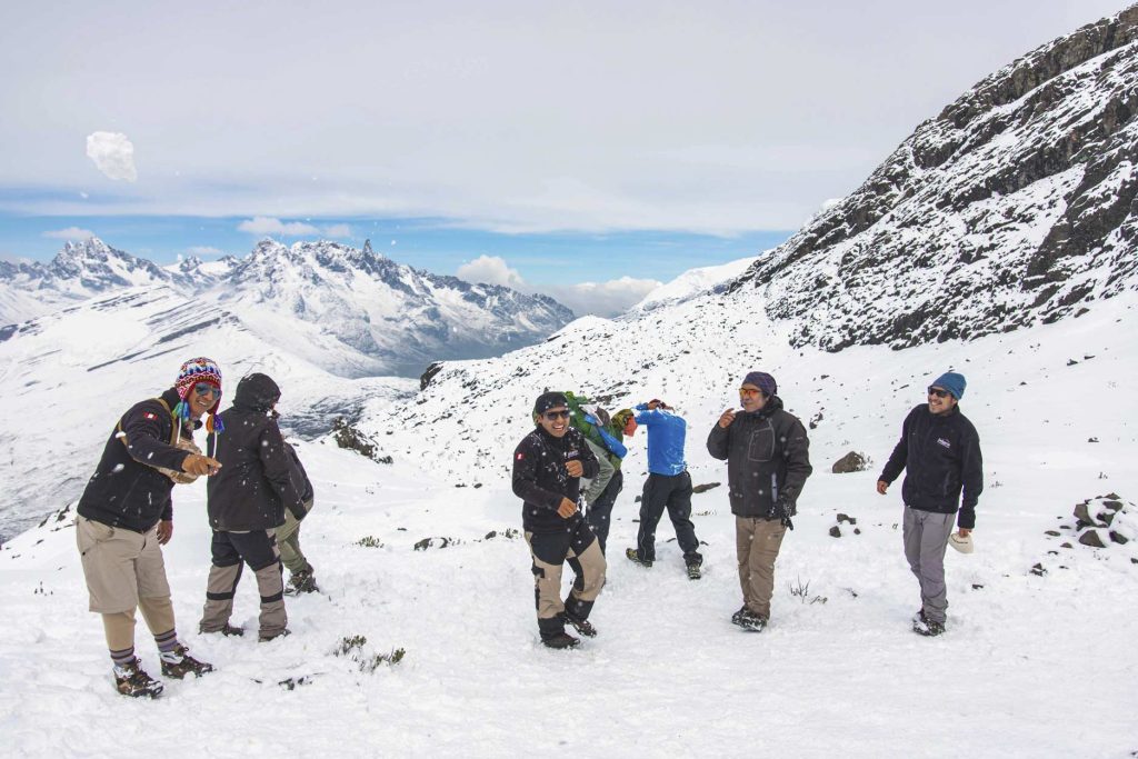 Tourists and hiking guides enjoy hiking on the Ausangate trail amid the snow.