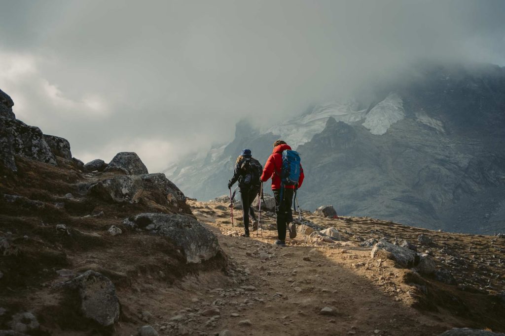 Hiker in the Peruvian Andes, surrounded by snow-capped mountains, enjoying a digital detox in the heart of nature.