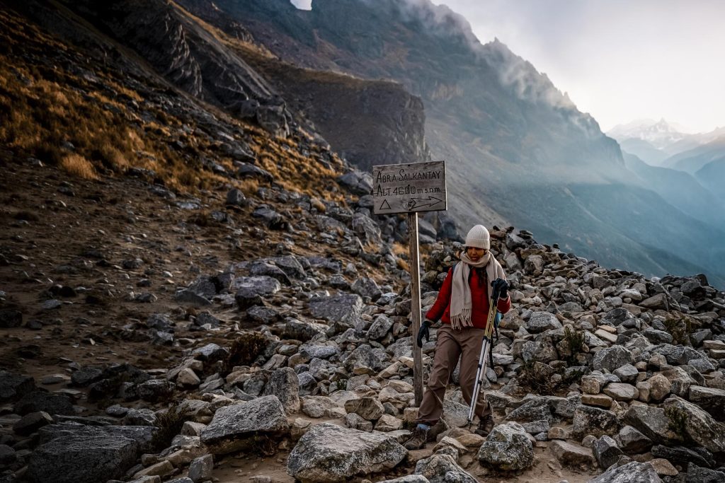 Lone tourist next to a sign at the Salkantay Pass.