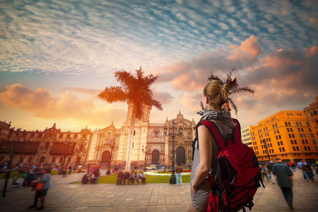 Tourist with a red backpack in Lima's main square.