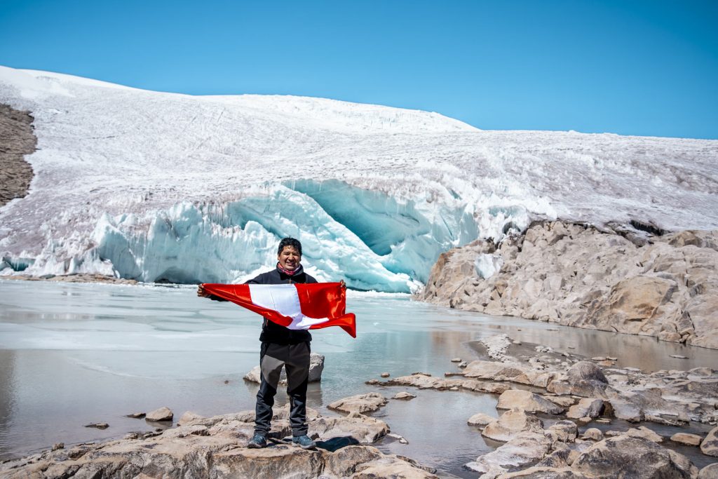 Tourist with his Peruvian flag with the Quelccaya glacier in the background.