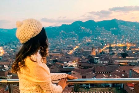 Tourist watching the impressive sunset of the city of Cusco