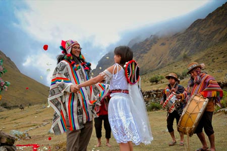 Couple dancing after their Andean marriage in front of the imposing Salkantay mountain