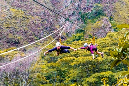 Two tourists enjoying the sport of zipline an adventure sport